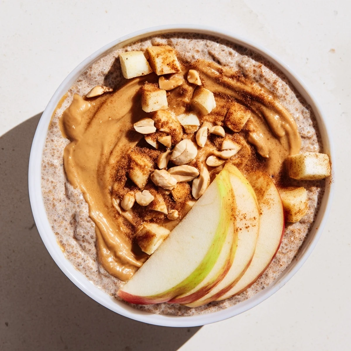 Creamy Apple-Chia Pudding is layered with peanut butter; smells of cinnamon and fresh apples.