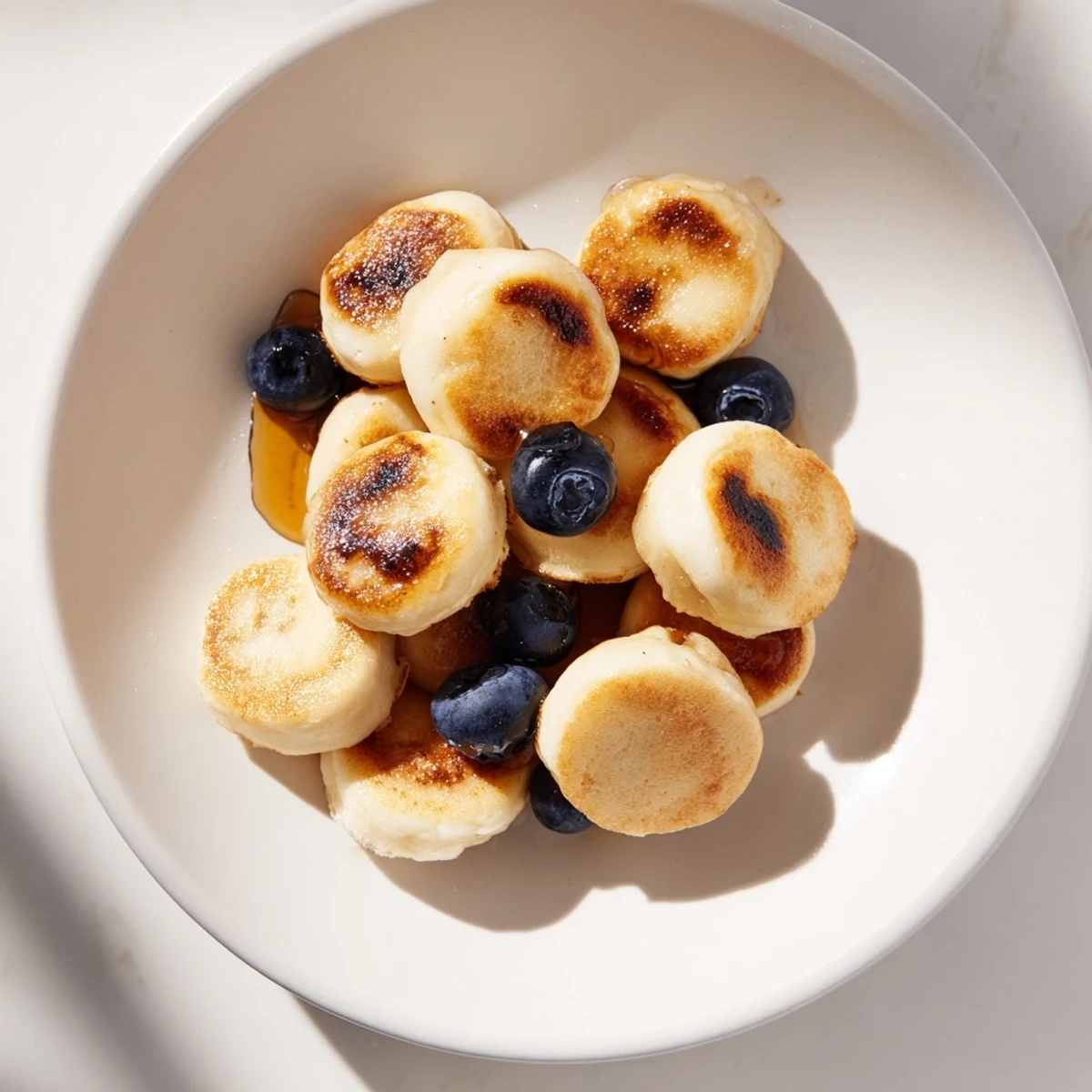 Fluffy pancake cereal, bite-sized American pancakes, ready to be enjoyed with maple syrup.