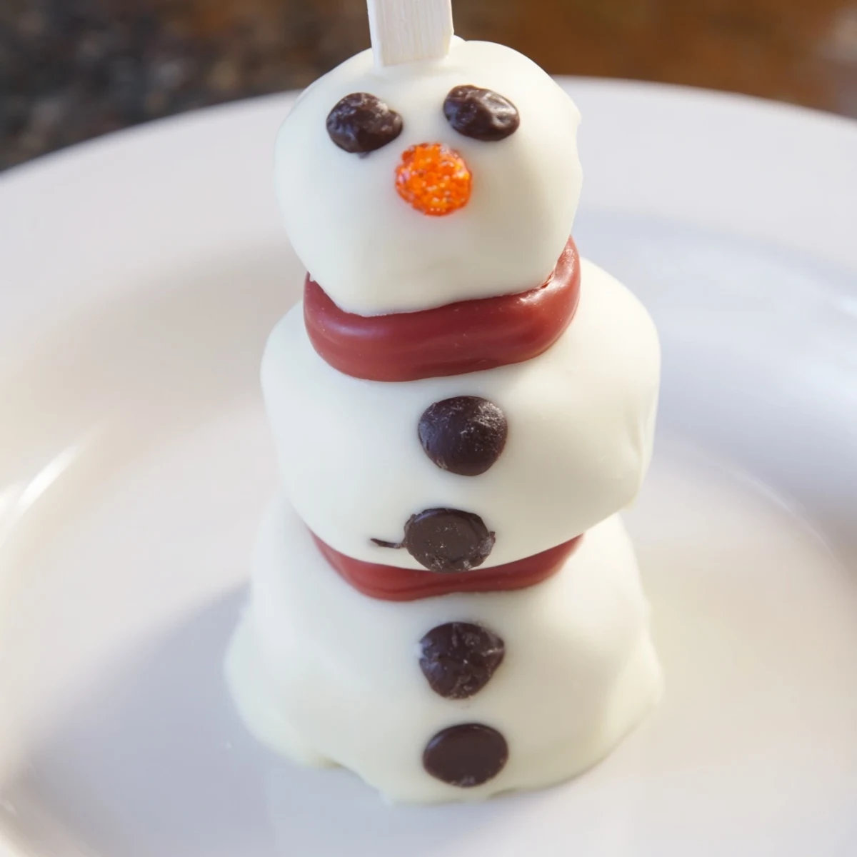 Express Snowman Marshmallow Pops dipped in glistening white chocolate, ready for a winter treat.
