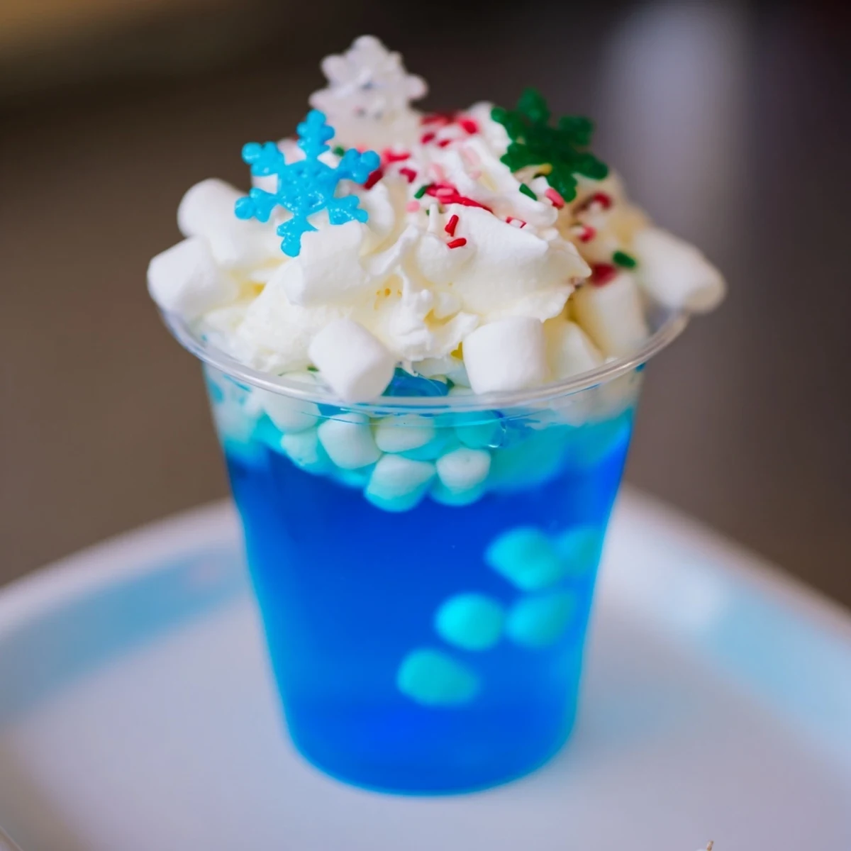 Snow globe Jello cups, a colorful treat filled with vibrant blue gelatin and tiny marshmallows.