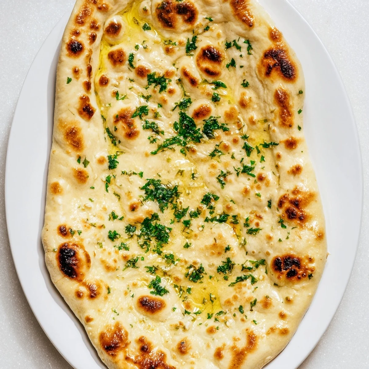 Warm, soft homemade garlic naan flatbread, perfect for dipping in curry or savoring the delicious garlic flavor.