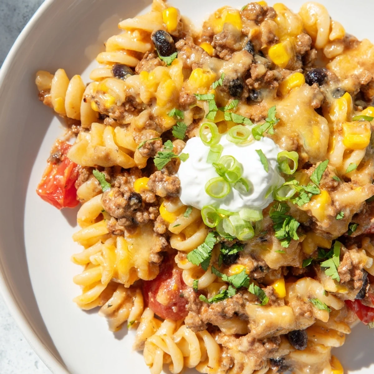 Steaming bowl of flavorful Cheesy Taco Pasta with melted cheese and fresh herbs, ready to serve.