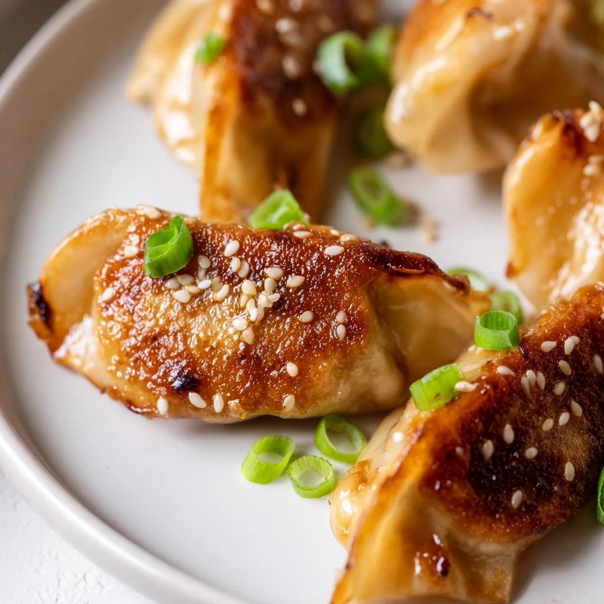 A close-up of beautifully cooked air fryer frozen dumplings, showcasing the sesame oil's savory flavor.