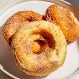 Picture fluffy 1-Minute Air Fryer Donuts, just pulled from the air fryer, ready to be coated with cinnamon.