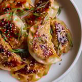 Golden brown air fryer frozen dumplings, glistening with sesame oil, ready to serve as an appetizer.