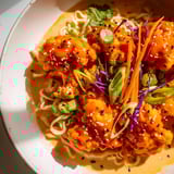 Buffalo Cauliflower Ramen, with vibrant green onions and crunchy sesame seeds topping the spicy ramen.