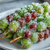Colorful frozen grape skewers with tangy lime sugar, an easy and vibrant treat for parties or picnics.  