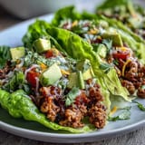 Juicy Turkey Taco Lettuce Wraps pictured with crisp lettuce and colorful fresh toppings.