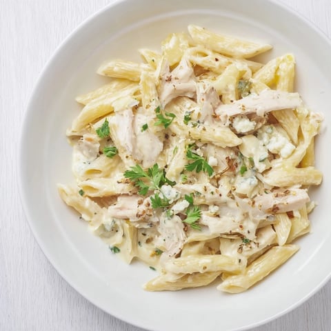 Creamy Spinach Artichoke Protein Pasta skillet, ready to serve with a garnish of Parmesan and fresh herbs.