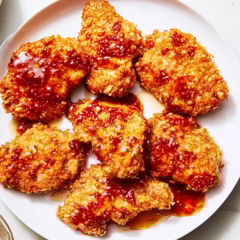 Golden-brown, crispy Hot Honey Crispy Chicken Thighs glistening with a sweet and spicy honey glaze.