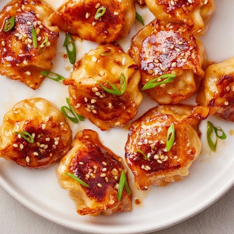 Crispy air fryer frozen dumplings glazed with sesame oil, garnished with fresh green onions.