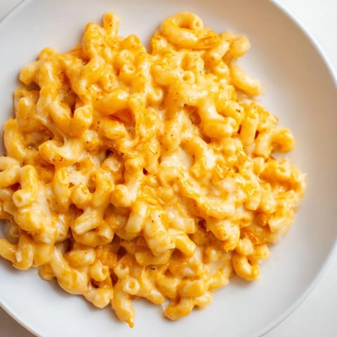 Warm, delicious One-Pot Butternut Squash Mac & Cheese, perfect comfort food, topped with extra cheese.