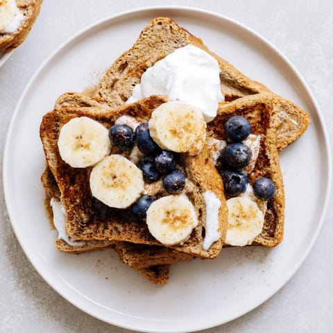 Warm and fluffy Protein French Toast, cooked to a perfect golden brown, ready to enjoy with syrup.