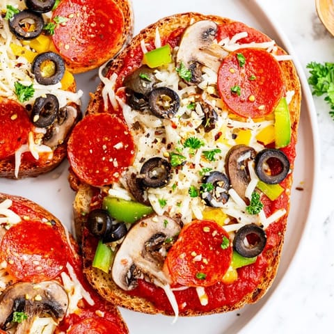 This close-up shows the crispy, cheesy Air Fryer Pizza Toast with fresh herbs as a beautiful meal.