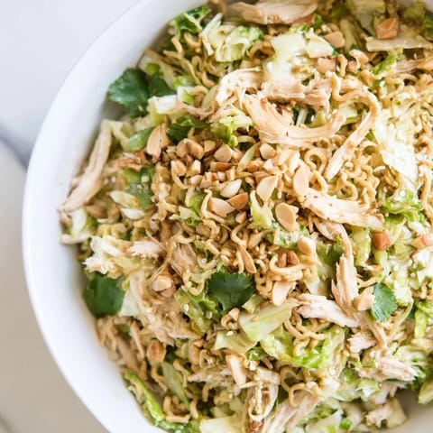 Freshly tossed Crunchy Ramen Chicken Salad featuring tender rotisserie chicken and crushed noodles, served as a light lunch.  