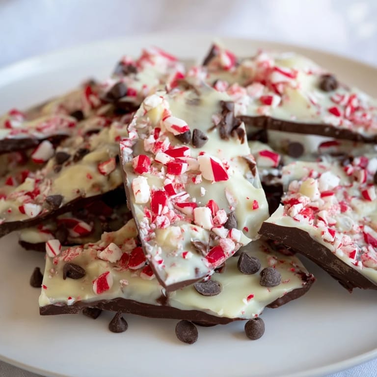 Close-up of freshly made peppermint bark shards, showcasing the vibrant red and white candy topping.