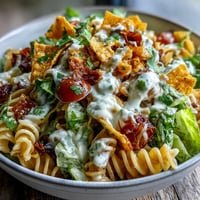 Taco Pasta Salad with Doritos and Avocado Ranch in a large bowl, garnished with fresh cilantro and colorful vegetables.