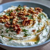 Creamy whipped feta dip with golden honey drizzle, crunchy walnuts, and fresh herbs, served with warm pita and crisp vegetable sticks.